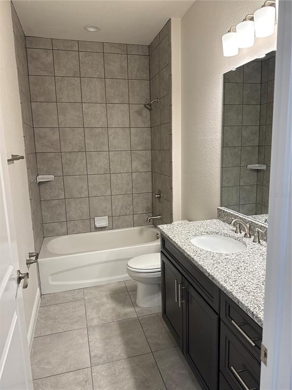 A bathroom features a tiled tub-shower combo, a dark wood vanity, and a granite countertop — 1464 SHADOW LANE, NORTH PORT, FL