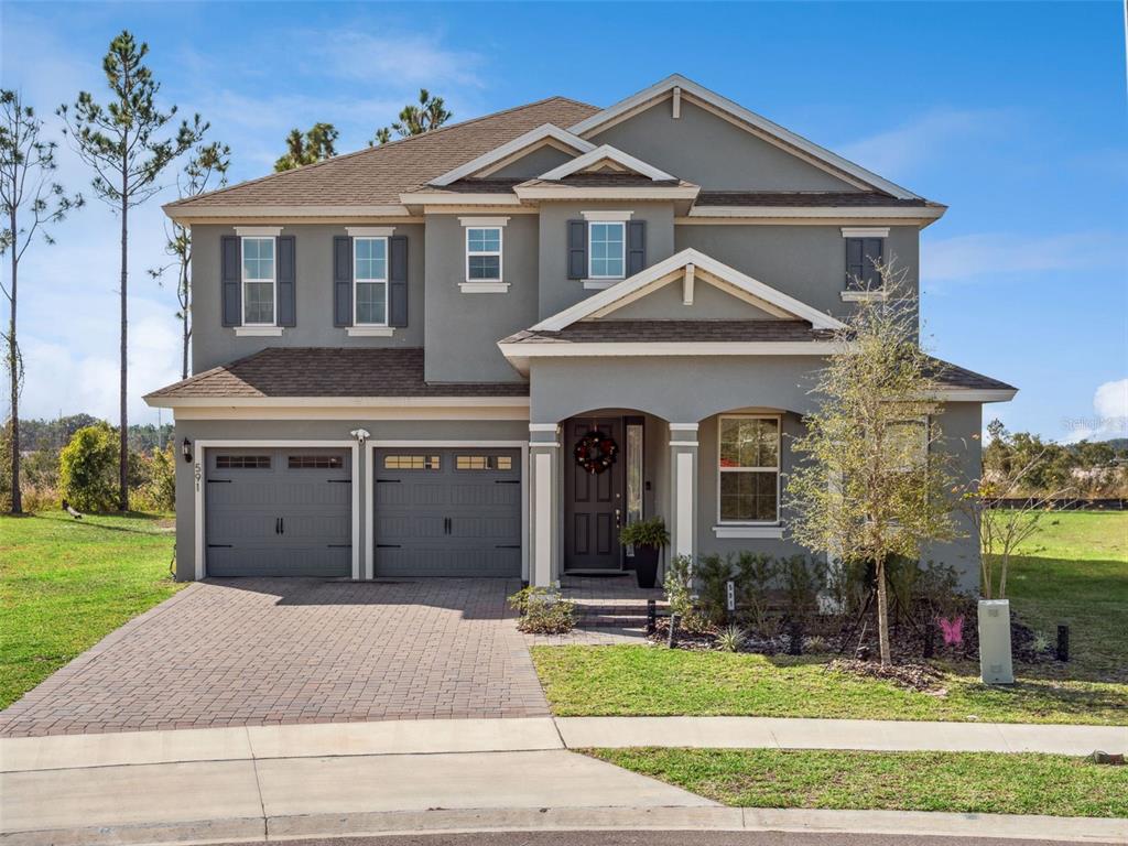 A two-story gray house with a two-car garage and a paved driveway — 591 VIA BELLA COURT, HOWEY IN THE HILLS, FL