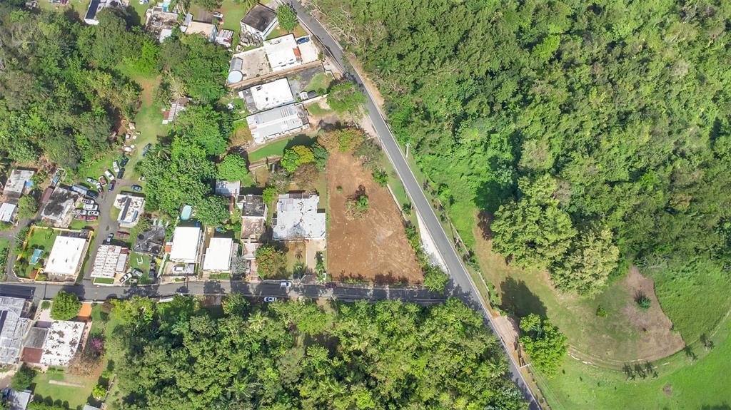 An aerial view shows a vacant rectangular lot situated between a road and residential houses — Km 3.6 695, DORADO, PR