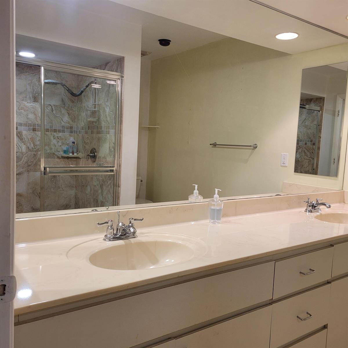 A bathroom features a double vanity with a large mirror and a glass-enclosed shower — 135 Meander Circle, Royal Palm Beach FL 33411, ROYAL PALM BEACH, FL