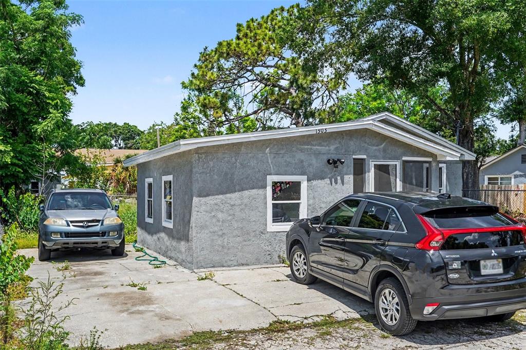 A gray single-story house with a concrete driveway and two parked cars — 1303 37TH STREET NW, WINTER HAVEN, FL