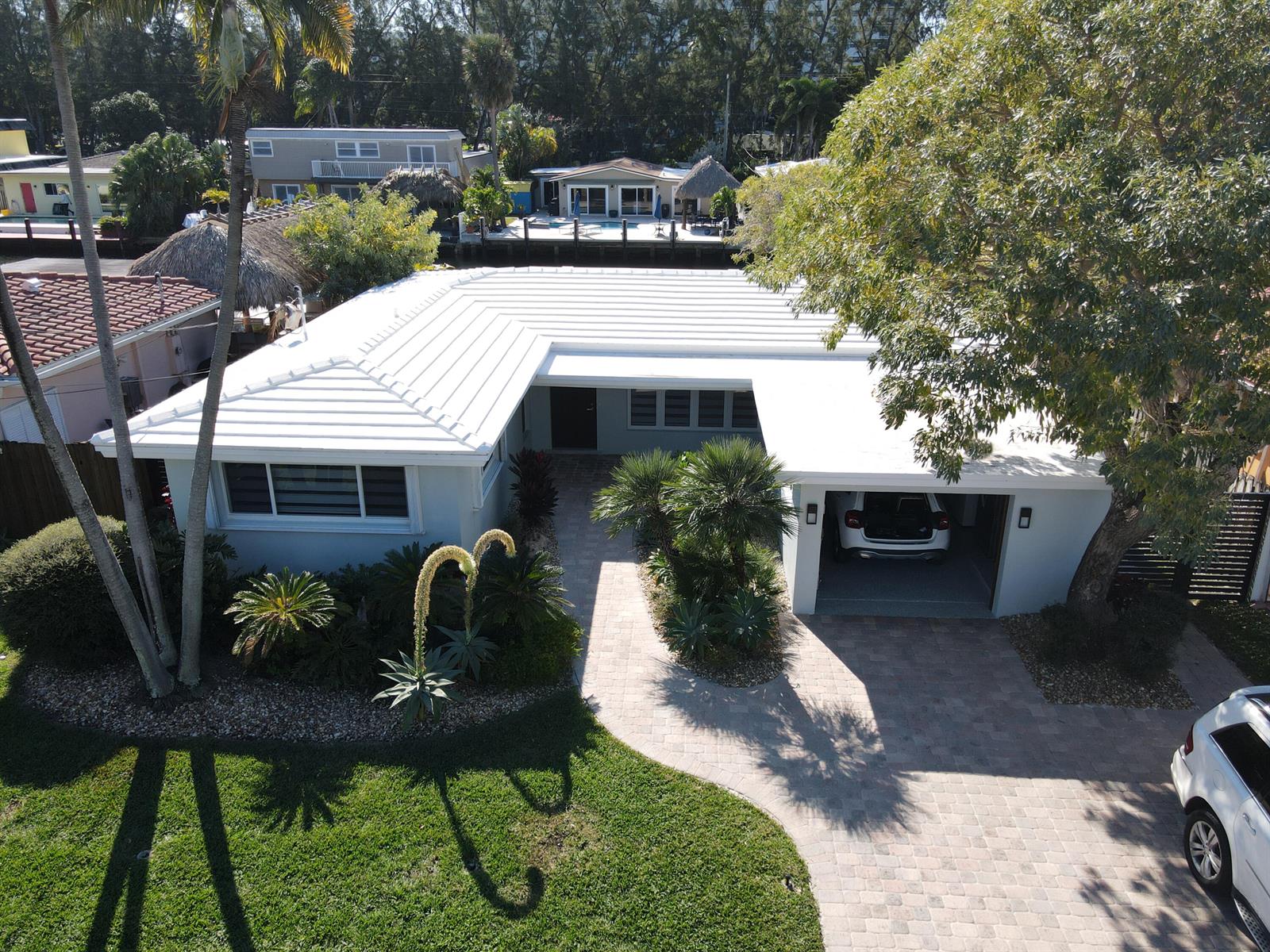 An aerial view of a single-story house with a white roof, garage, and paved driveway — 2548 SE 14th Street E, Pompano Beach FL 33062, POMPANO BEACH, FL