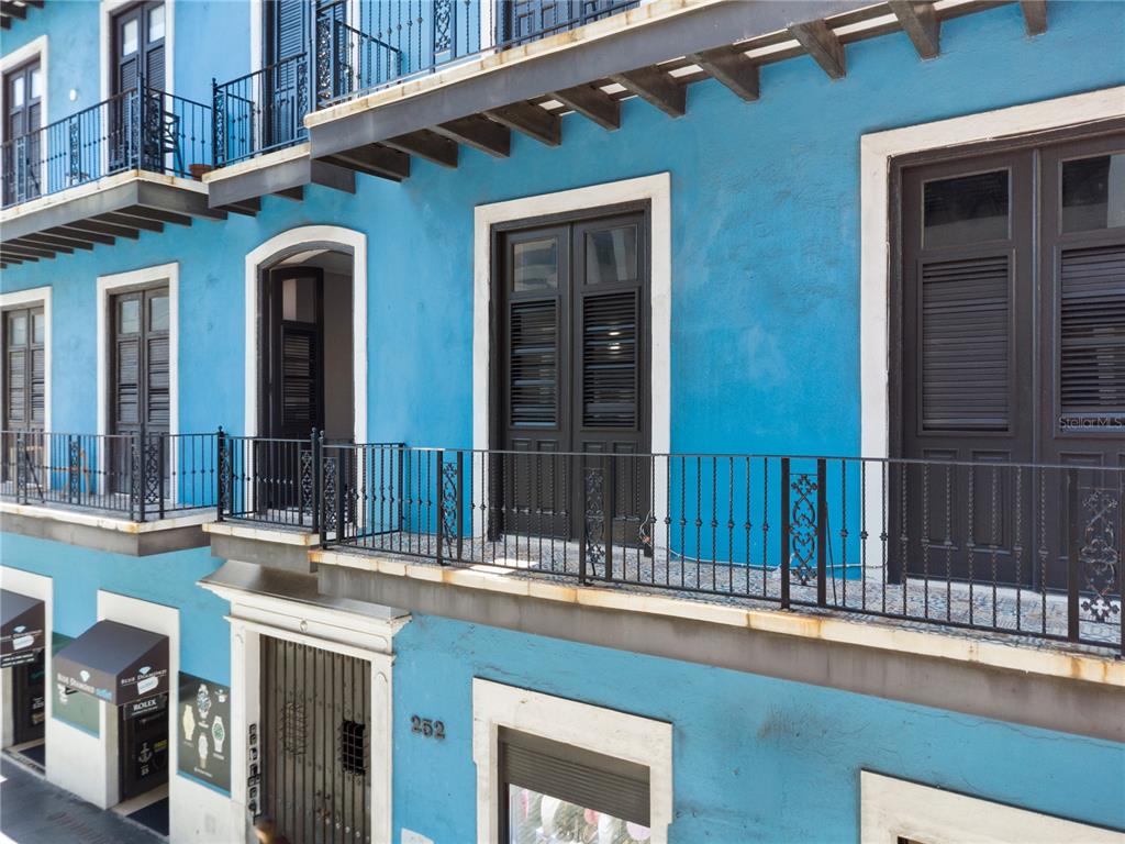 A bright blue building exterior features dark wooden doors, balconies with iron railings, and awnings — 252 CALLE FORTALEZA UNIT 252, SAN JUAN, PR