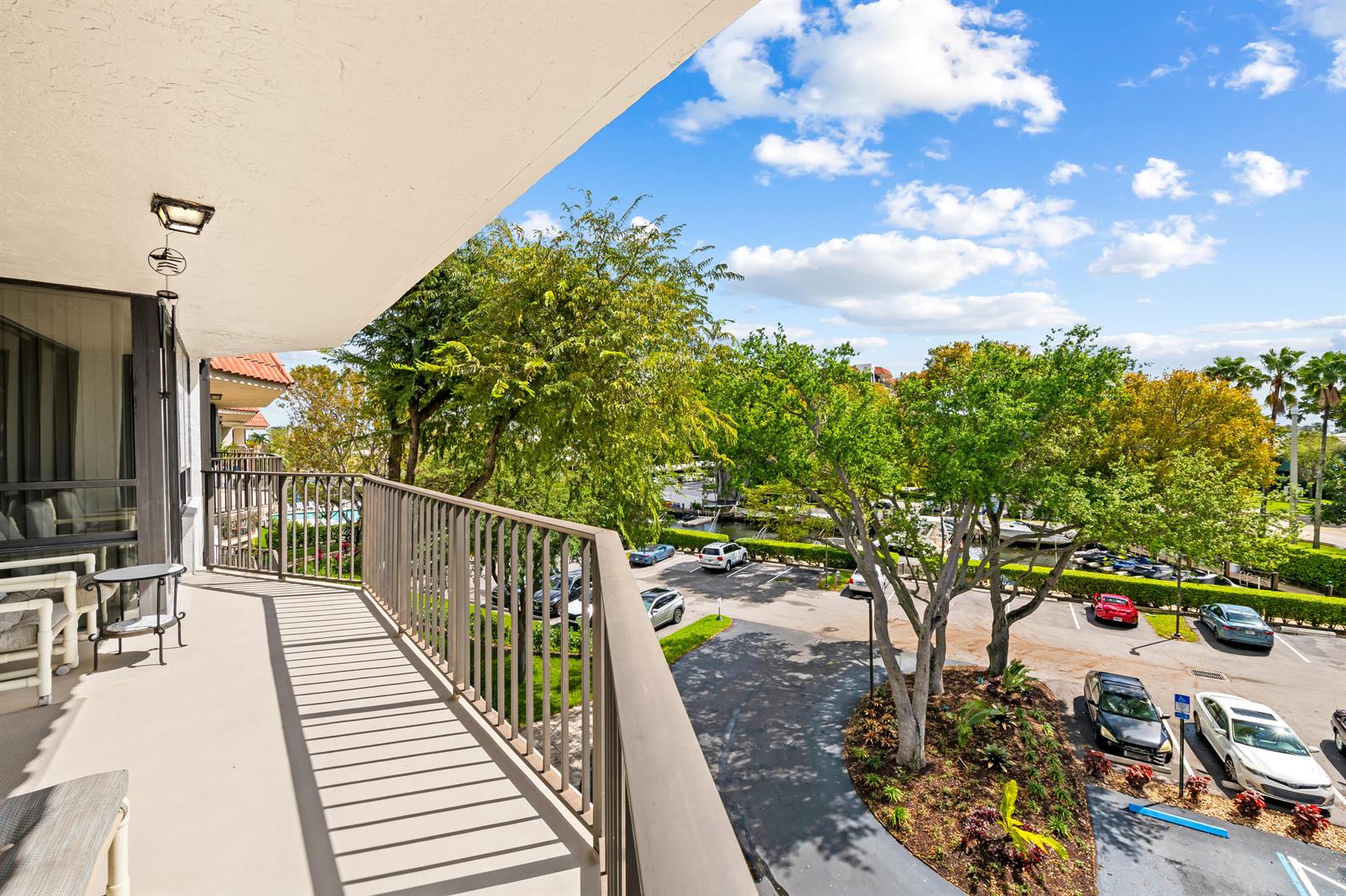 A balcony with a metal railing overlooks a parking lot, trees, and a waterway — 799 Jeffery Street # 4050, Boca Raton FL 33487, BOCA RATON, FL