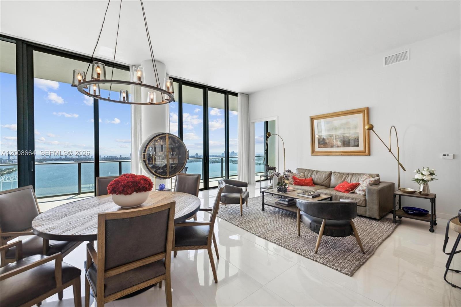 A modern living and dining area features floor-to-ceiling windows with a panoramic water view — 480 NE 31st St, Miami FL 33137, MIAMI, FL