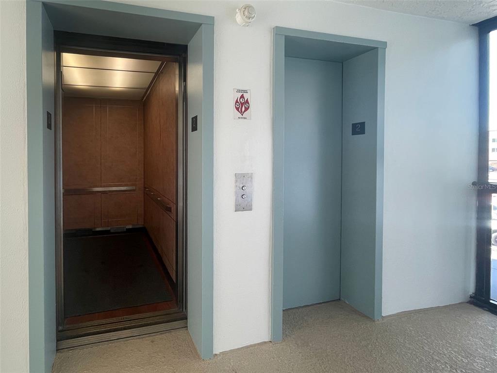 Two elevator doors are set into a white wall in a building hallway — 232 SAINT AUGUSTINE AVENUE UNIT 207, VENICE, FL