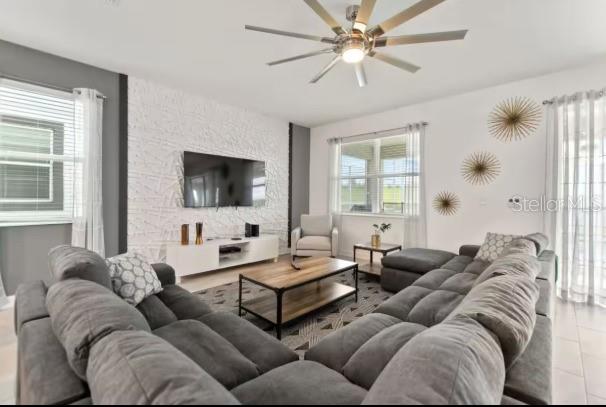 A living room features a large gray sectional sofa, a textured white wall, and television — 9254 SOMMERSET HILLS DRIVE, DAVENPORT, FL