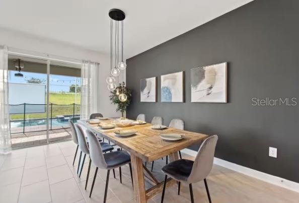 A dining room features a wooden table, grey chairs, a dark accent wall, and pool views — 9254 SOMMERSET HILLS DRIVE, DAVENPORT, FL