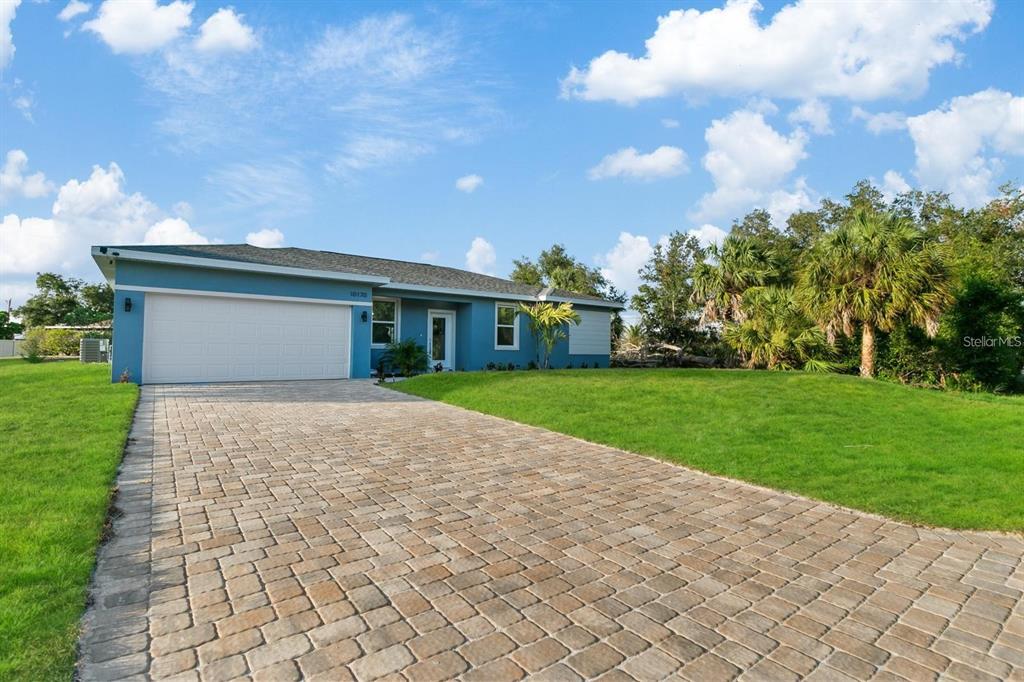 A blue single-story house features a white garage door and a paved driveway — 3471 WINONA STREET, PORT CHARLOTTE, FL