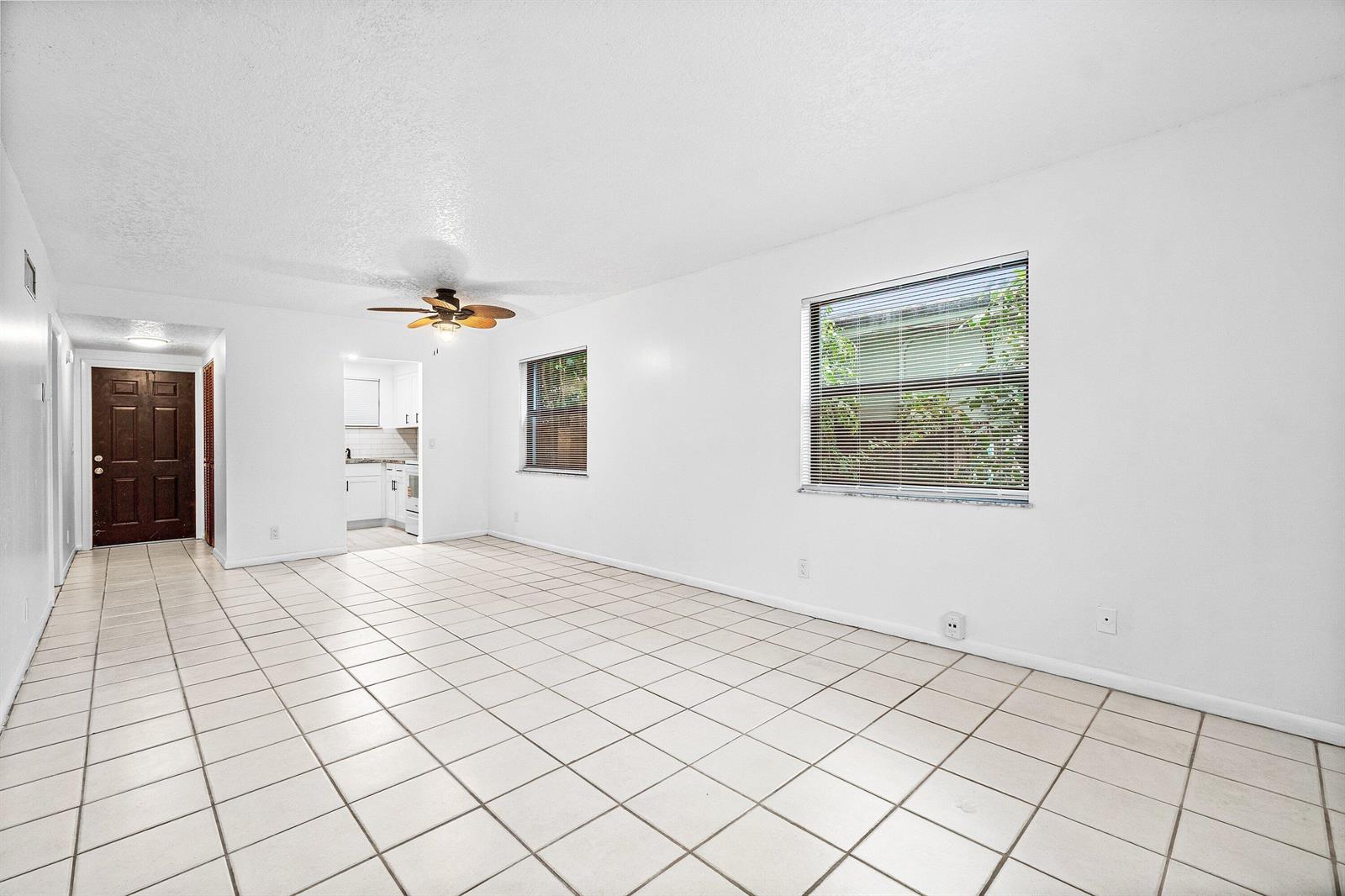A bright, empty living room features white walls, light-colored tile flooring, and a ceiling fan — 626 N Federal Highway Unit 3, FL 33460, FL