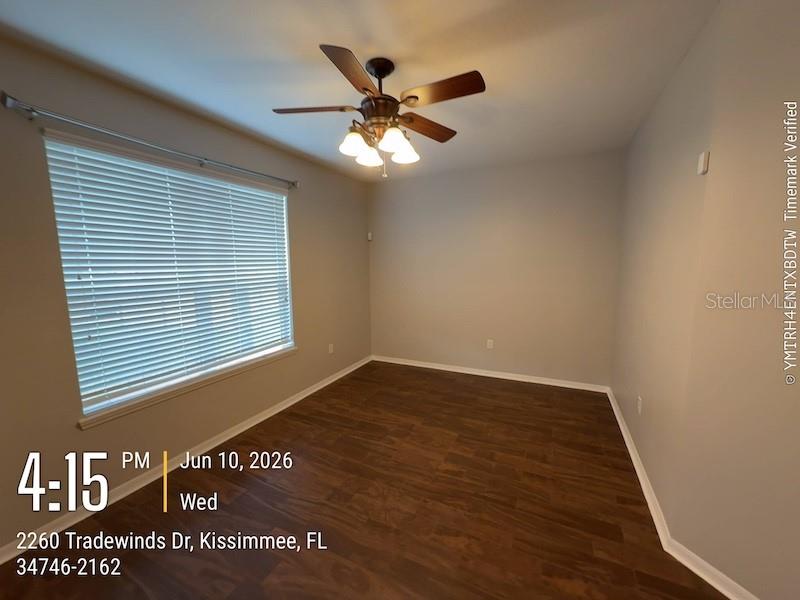 An empty bedroom features dark wood-look flooring, light gray walls, and a ceiling fan — 2260 TRADEWINDS DRIVE, KISSIMMEE, FL