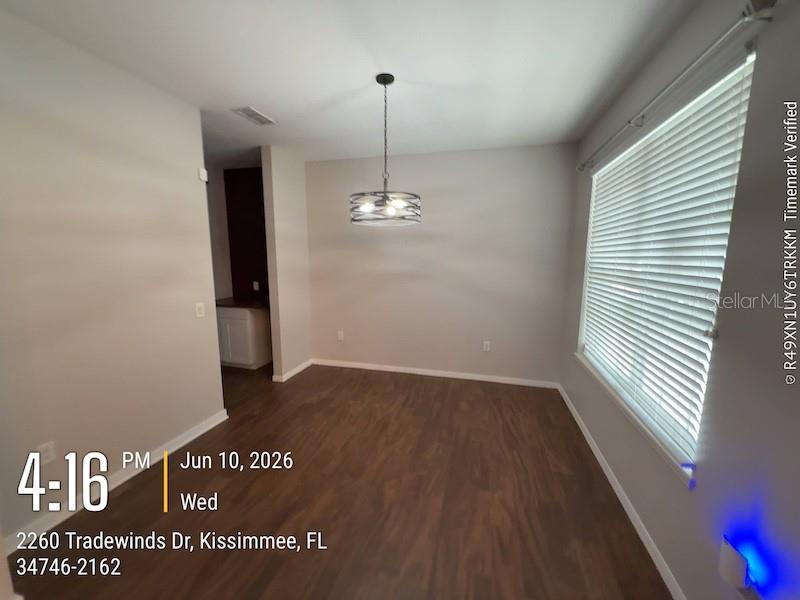 A dining area features dark wood-look flooring, light gray walls, and a modern metal chandelier — 2260 TRADEWINDS DRIVE, KISSIMMEE, FL