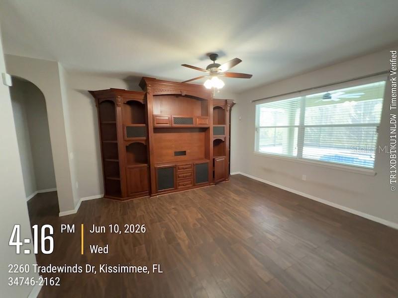 A built-in desk with white cabinets and a wood-paneled accent wall in a room — 2260 TRADEWINDS DRIVE, KISSIMMEE, FL