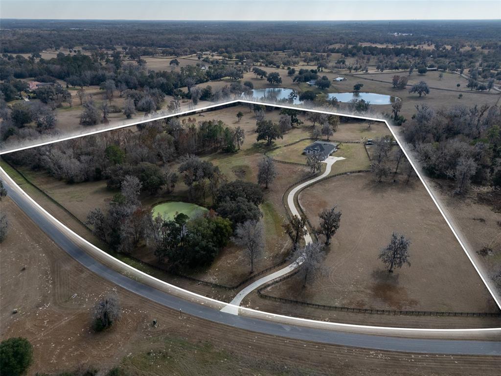An aerial view shows a house with a long driveway on a large, fenced lot — 11920 SE 22ND AVENUE ROAD, OCALA, FL