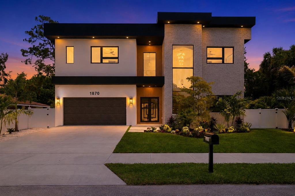 A modern two-story house features a flat roof, stone accents, and a two-car garage — 1870 JASMINE DRIVE, SARASOTA, FL
