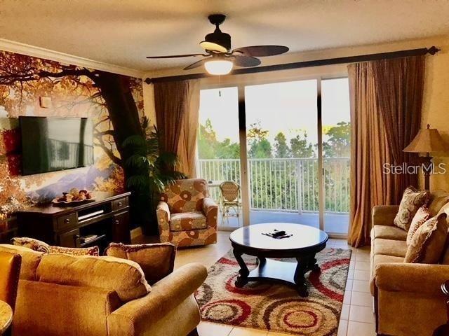 A living room features a patterned rug, a round coffee table, and a wall mural — 13415 BLUE HERON BEACH DRIVE UNIT 304, ORLANDO, FL