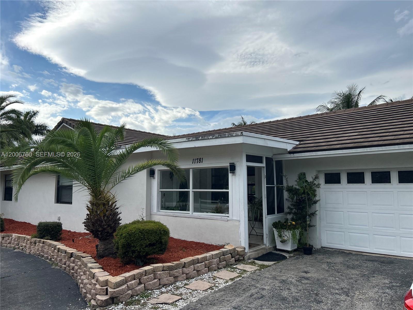 A single-story house features a white exterior, a tiled roof, and a landscaped front yard — 11781 NW 14th St, Plantation FL 33323, PLANTATION, FL