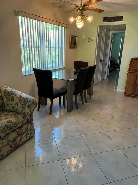 A dining area features a glass table, black chairs, tile flooring, and a ceiling fan — 457 Flanders # 457, Delray Beach FL 33484, DELRAY BEACH, FL