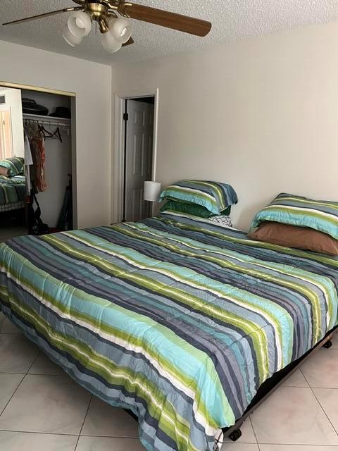 A bedroom features a bed with a striped comforter, a ceiling fan, and a closet — 457 Flanders # 457, Delray Beach FL 33484, DELRAY BEACH, FL