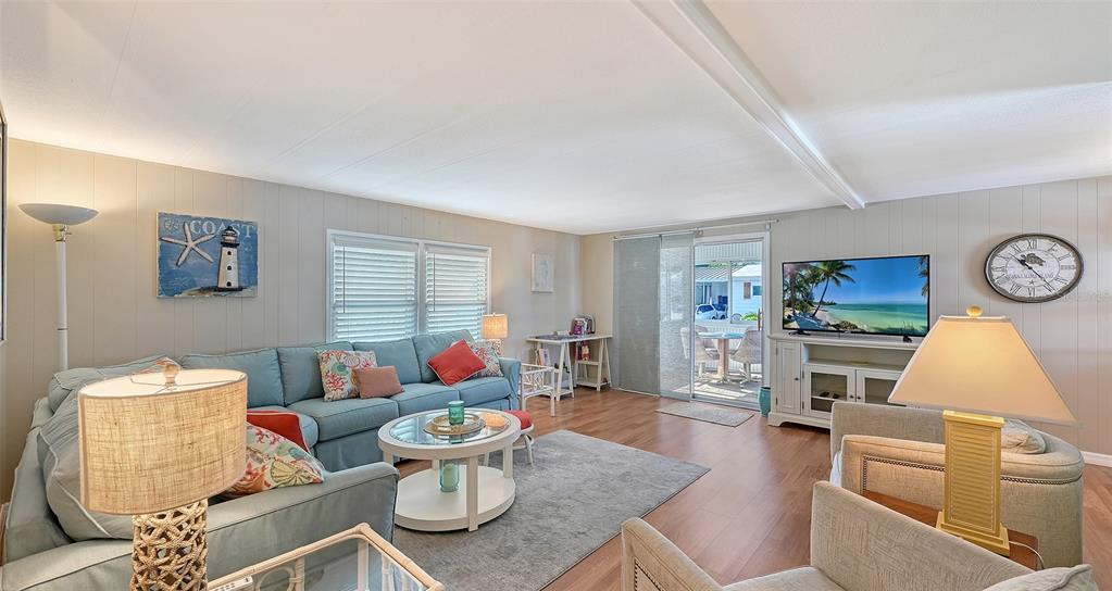 A living room features a blue sectional sofa, a round coffee table, and a television — 49 CABALLO WAY, BRADENTON, FL