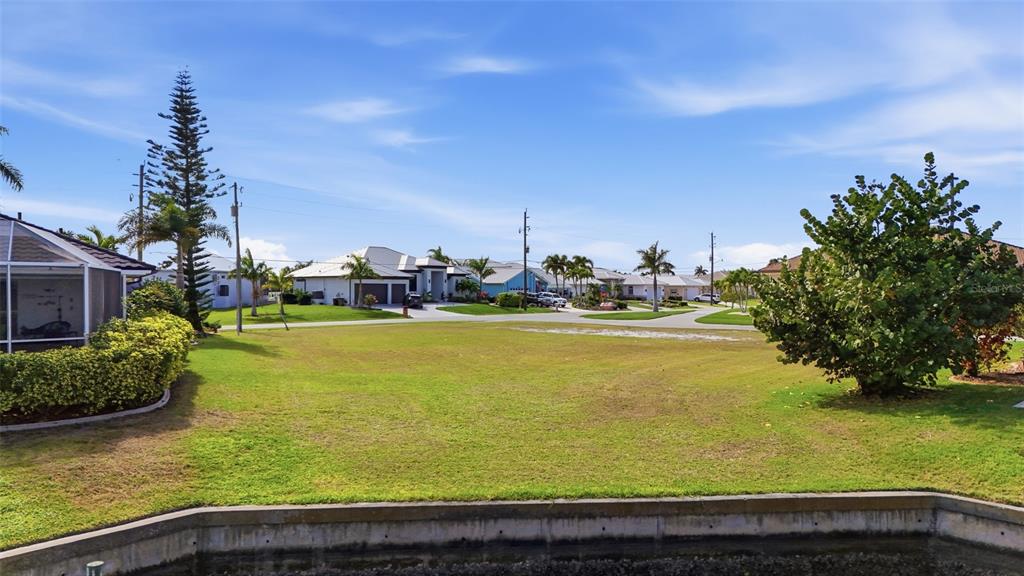 A vacant grassy lot sits along a concrete seawall in a residential neighborhood — 3460 OWL COURT, PUNTA GORDA, FL