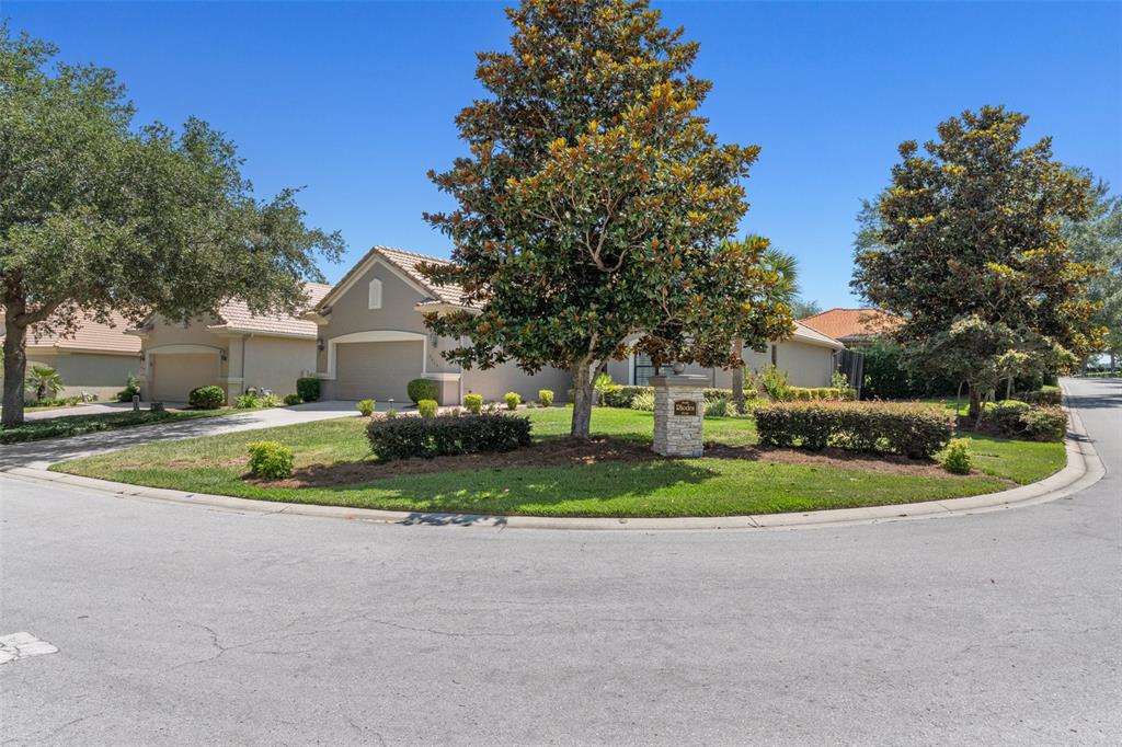 A single-story house with a tan exterior, a two-car garage, and a large front yard — 2015 N RHODES POINT, HERNANDO, FL