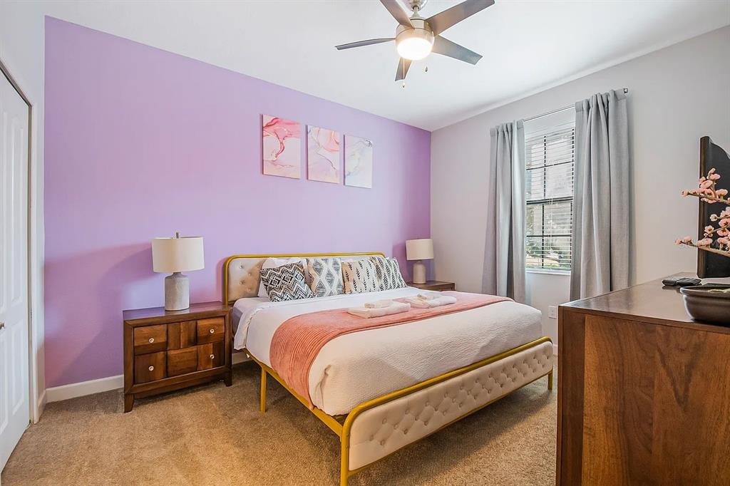 A bedroom features a purple accent wall, a gold-framed bed, and wood furniture — 1433 THUNDERBIRD ROAD, DAVENPORT, FL