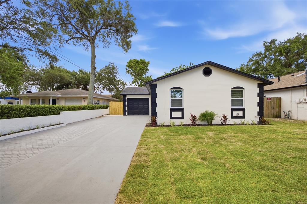 A single-story house with a white exterior, black trim, and a concrete driveway — 1001 CARLTON STREET, CLEARWATER, FL
