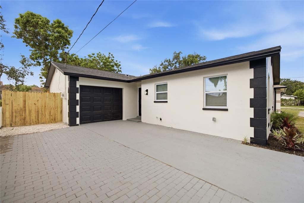 A single-story house with a white stucco exterior, black trim, and a paved driveway — 1001 CARLTON STREET, CLEARWATER, FL