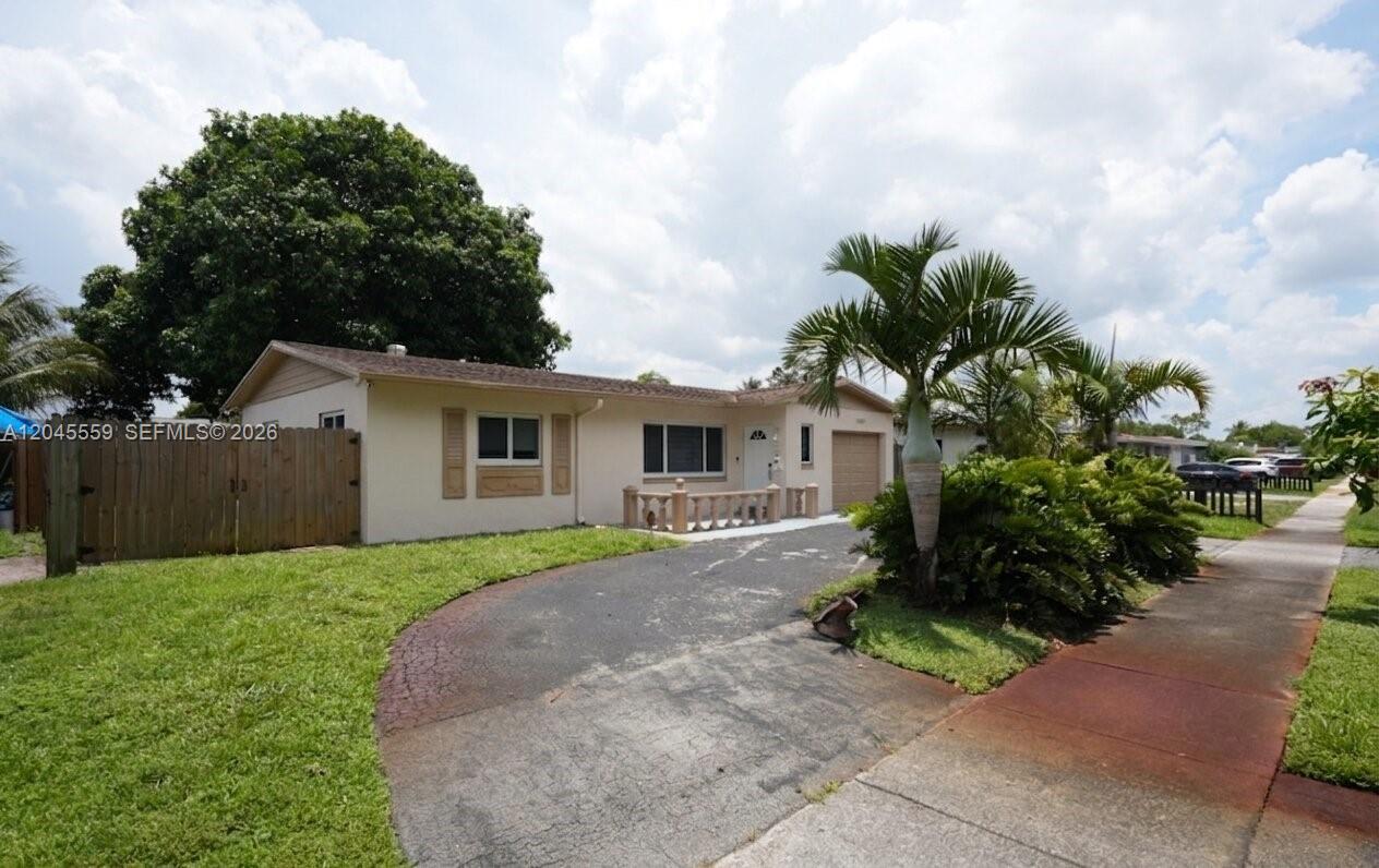 A single-story house with a beige exterior, a curved driveway, and a small front porch — 7304 Mckinley St, Hollywood FL 33024, HOLLYWOOD, FL