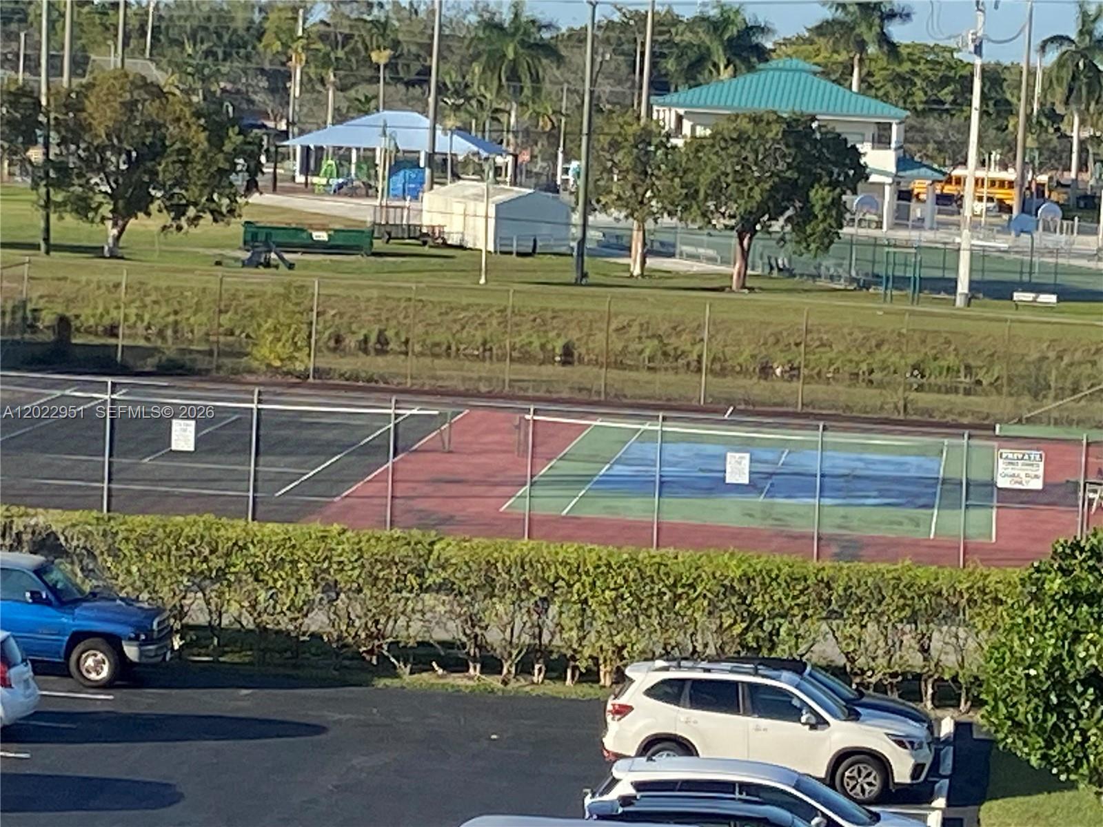 An elevated view shows tennis courts, a parking lot, and a park with trees — 7502 NW 30th Pl # 417, Sunrise FL 33313, SUNRISE, FL