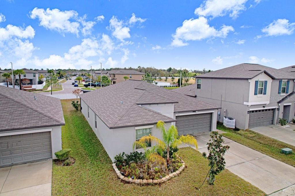 An aerial view shows the exterior of a suburban house with a gray roof — 13630 WILD GINGER STREET, RIVERVIEW, FL
