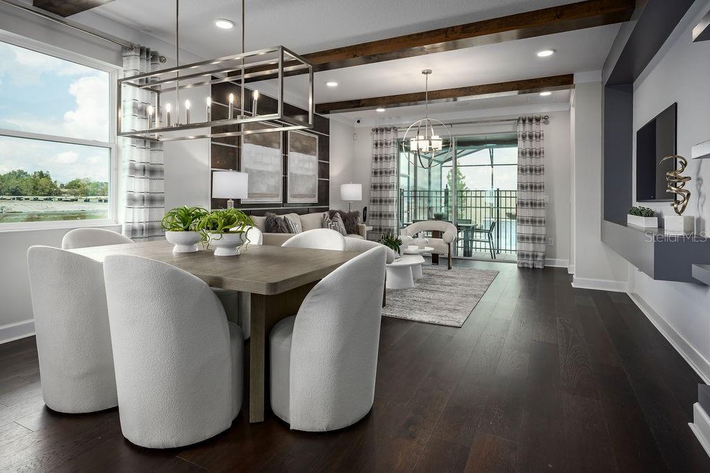 A dining area with a rectangular table and chairs opens into a living room space — 5328 TEIRGARTEN STREET, ST CLOUD, FL
