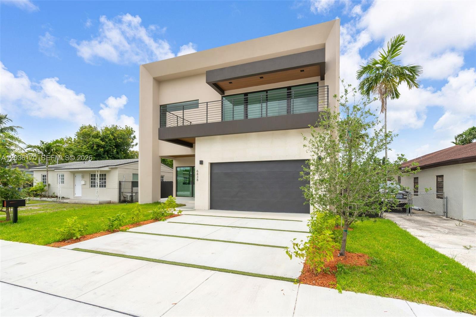 A modern two-story house features a concrete driveway, a garage, and a second-floor balcony — 6438 SW 23rd St, Miami FL 33155, MIAMI, FL