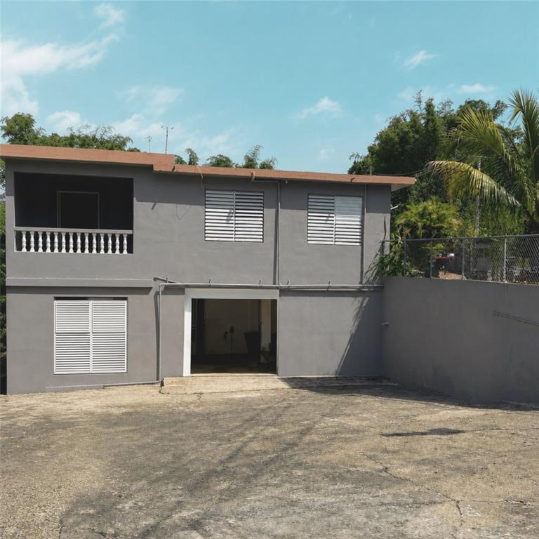 A two-story gray house with a balcony, louvered windows, and an open ground-level garage — PR 523 KM0.3 ROAD, UTUADO, PR