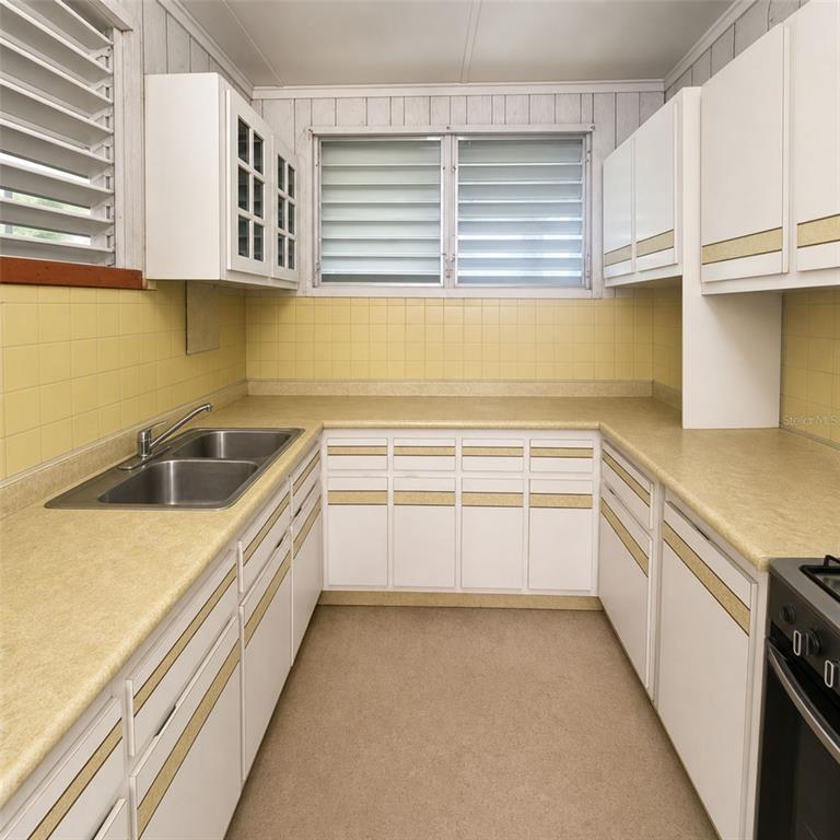 A kitchen features yellow tiled walls, white cabinets with gold trim, and a double sink — PR 523 KM0.3 ROAD, UTUADO, PR