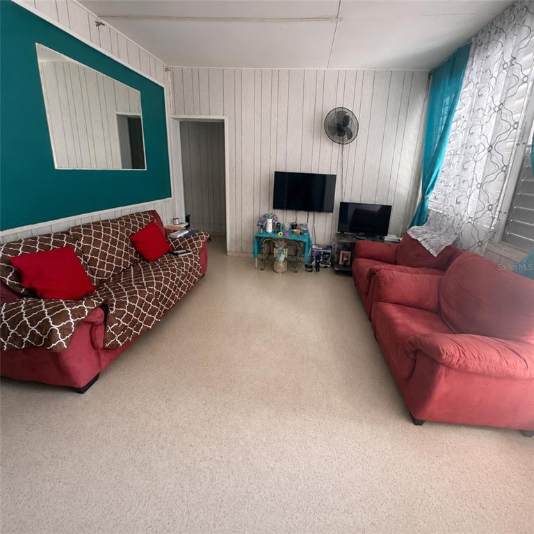 A living room features wood-paneled walls, two sofas, and a wall-mounted television — PR 523 KM0.3 ROAD, UTUADO, PR