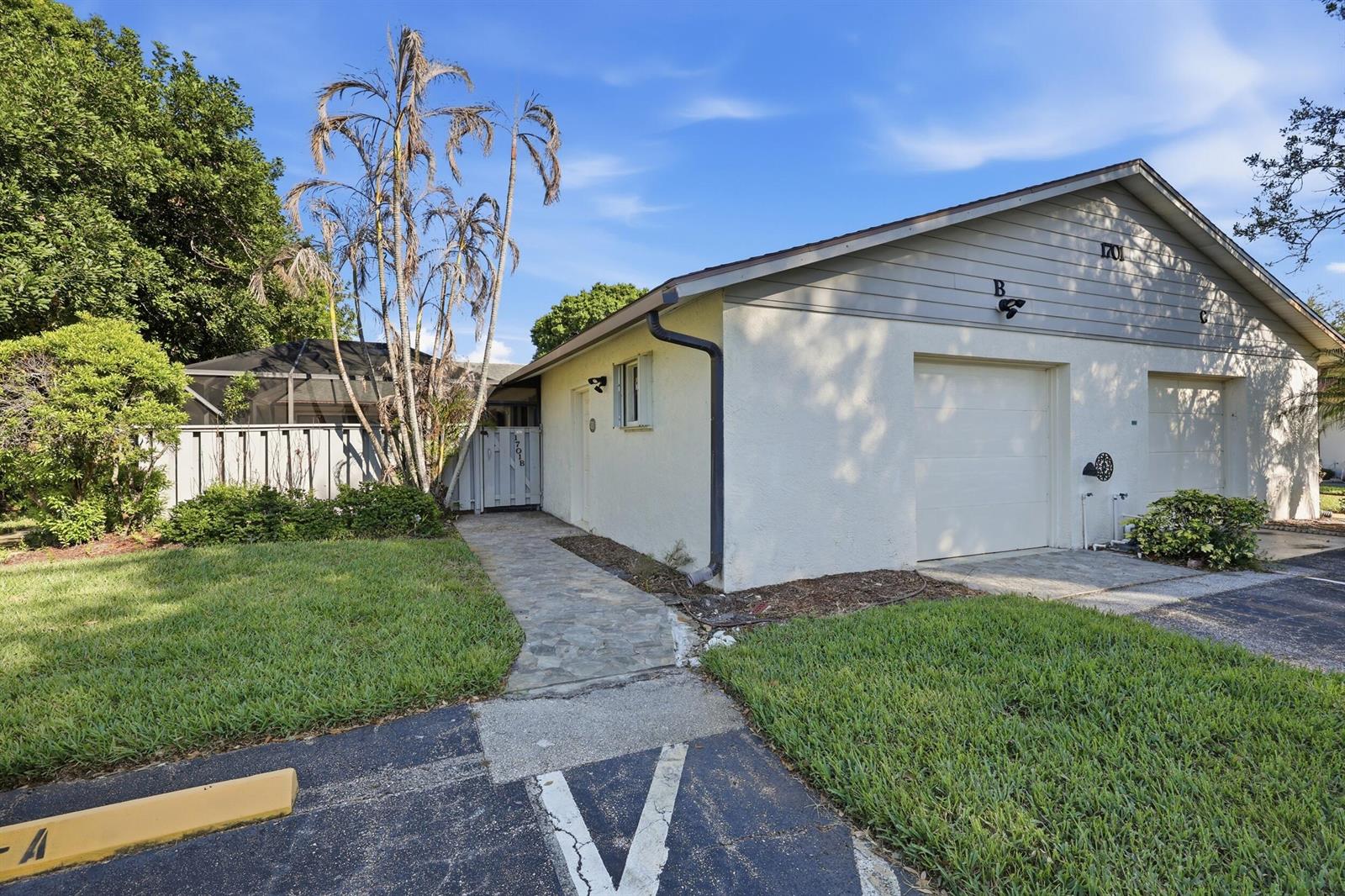 A single-story duplex building with a stone walkway, two garage doors, and a palm tree — 1701 Mariners Cove, Fort Pierce FL 34950, FORT PIERCE, FL