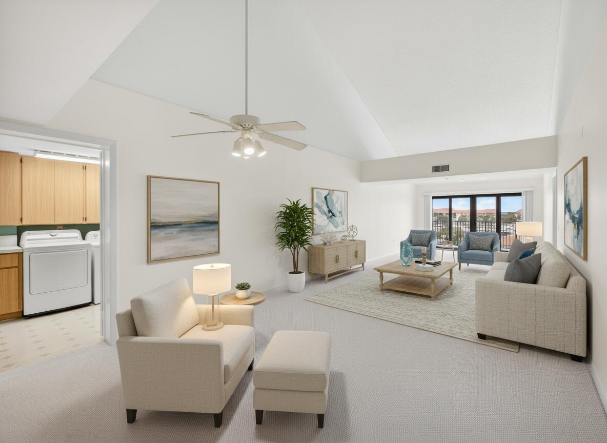 A bright living room with vaulted ceilings, neutral carpet, and a view of a balcony — 601 Seafarer Circle # 504, Jupiter FL 33477, JUPITER, FL