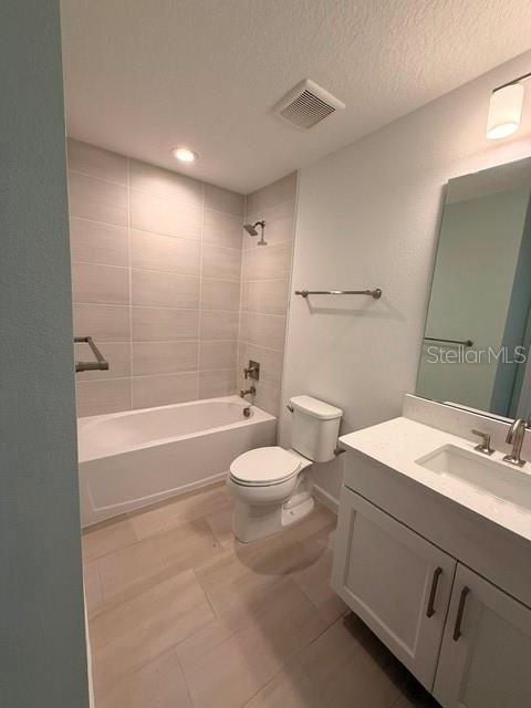 A bathroom features a white vanity, a toilet, and a bathtub with light-colored tile walls — 2592 LONG PINE AVENUE, APOPKA, FL
