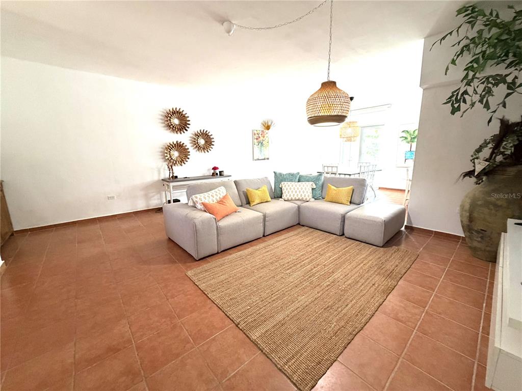 A living room features a light gray sectional sofa, a jute rug, and tile flooring — 693 NORTH COAST VILLAGE UNIT 236, VEGA ALTA, PR