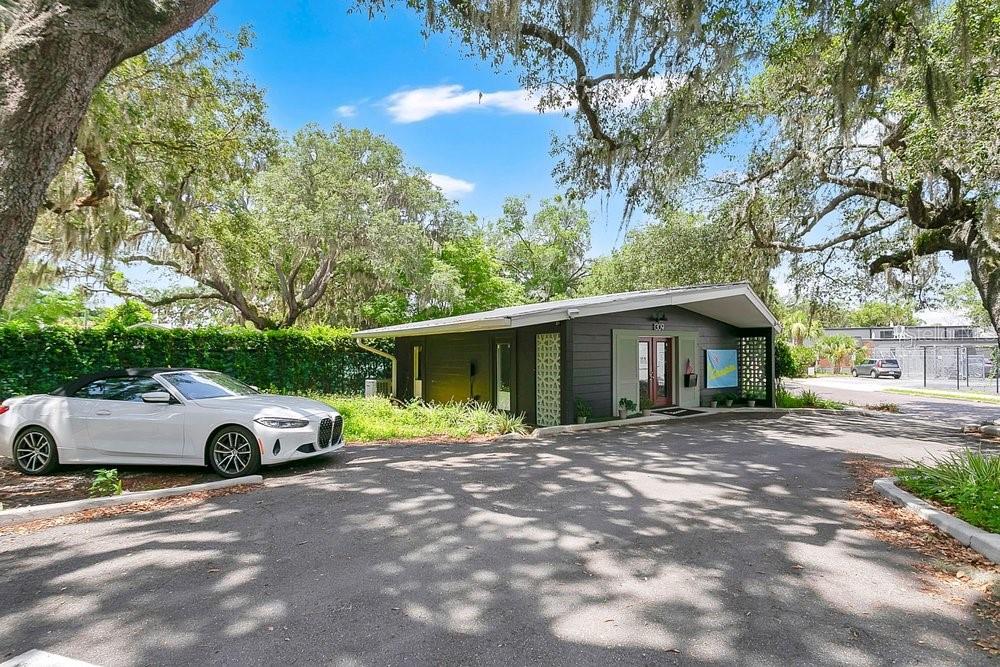 A single-story gray building with a flat roof sits in a parking lot under trees — 1309 WILFRED DRIVE, ORLANDO, FL