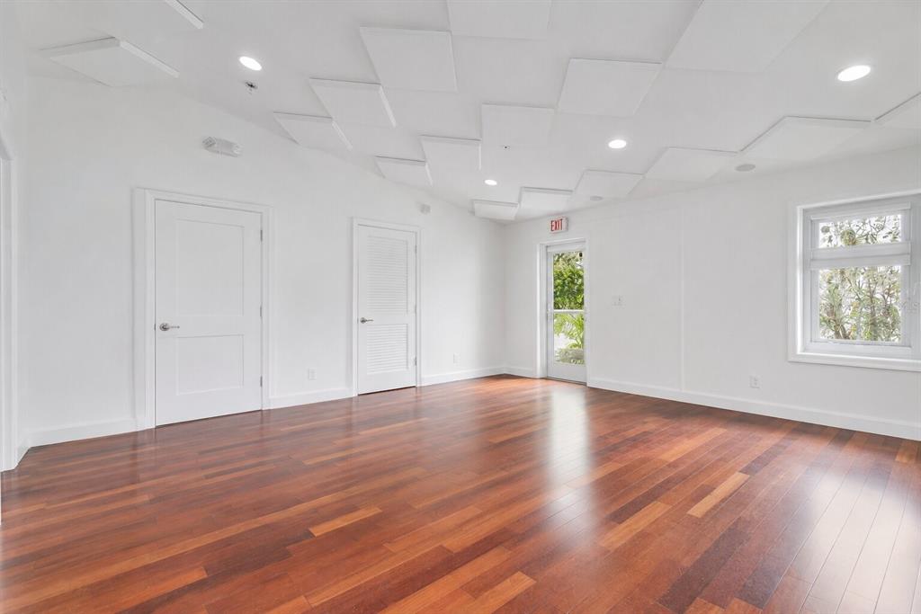 An empty room with white walls, hardwood floors, and a geometric acoustic tile ceiling — 1309 WILFRED DRIVE, ORLANDO, FL