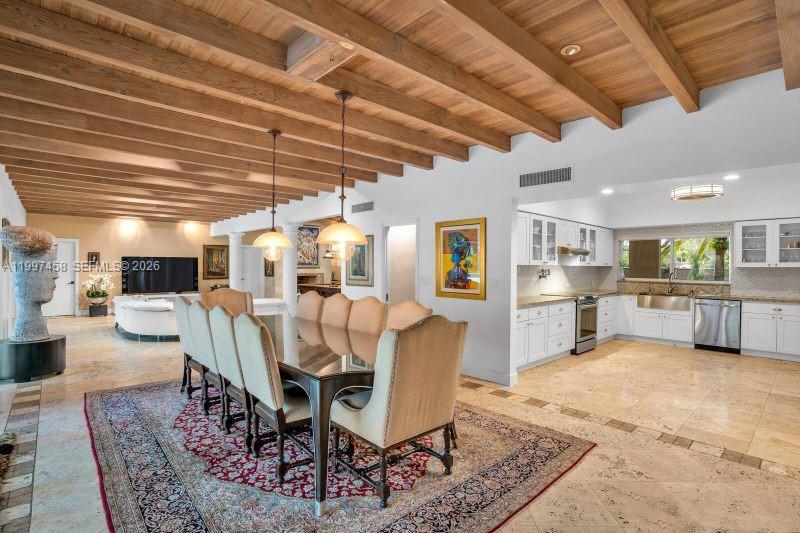 A dining area with a wooden beamed ceiling sits adjacent to an open-concept kitchen — 7405 SW 79th Ct, Miami FL 33143, MIAMI, FL