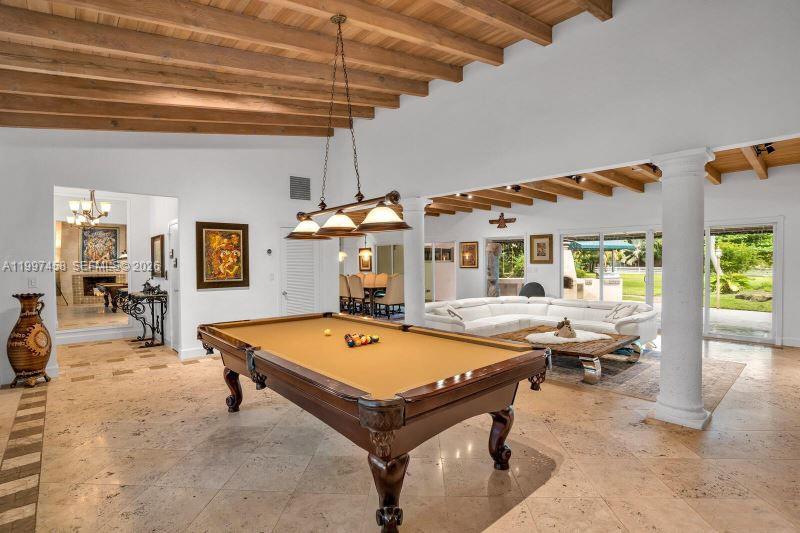 A spacious living area features a pool table, white sectional sofa, and exposed wood beams — 7405 SW 79th Ct, Miami FL 33143, MIAMI, FL