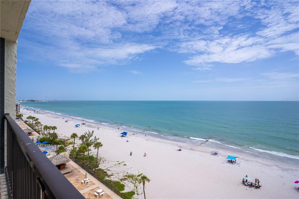 A high-angle view of a sandy beach and ocean from a balcony — 15000 GULF BOULEVARD UNIT 907, MADEIRA BEACH, FL