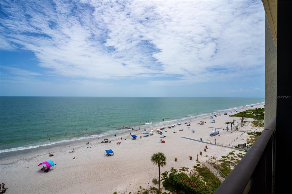 An elevated view of a sandy beach and ocean from a balcony — 15000 GULF BOULEVARD UNIT 907, MADEIRA BEACH, FL