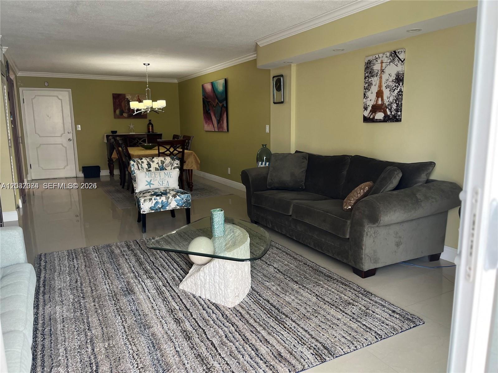 A living and dining area features olive walls, a gray sofa, and a glass coffee table — 1849 S Ocean Dr # 0, Hallandale Beach FL 33009, HALLANDALE BEACH, FL