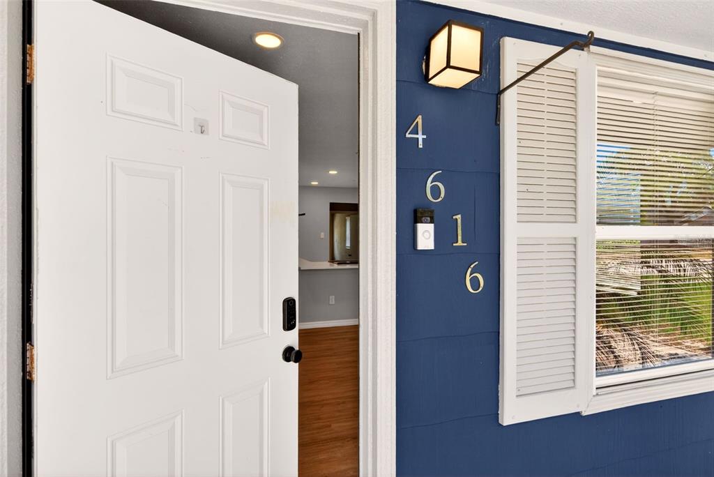 A white front door stands open, revealing a glimpse of an interior room with wood floors — 4616 9TH AVENUE S, ST PETERSBURG, FL
