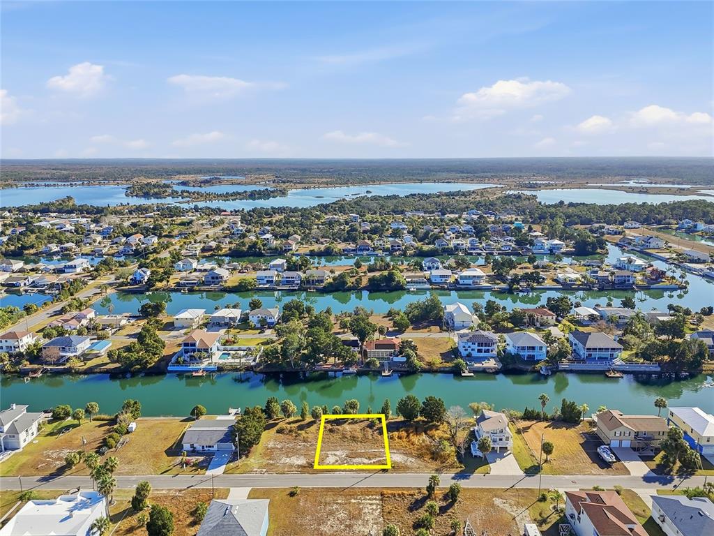 An aerial view shows a vacant rectangular lot situated along a canal in a residential neighborhood — 3310 GARDENIA DRIVE, HERNANDO BEACH, FL